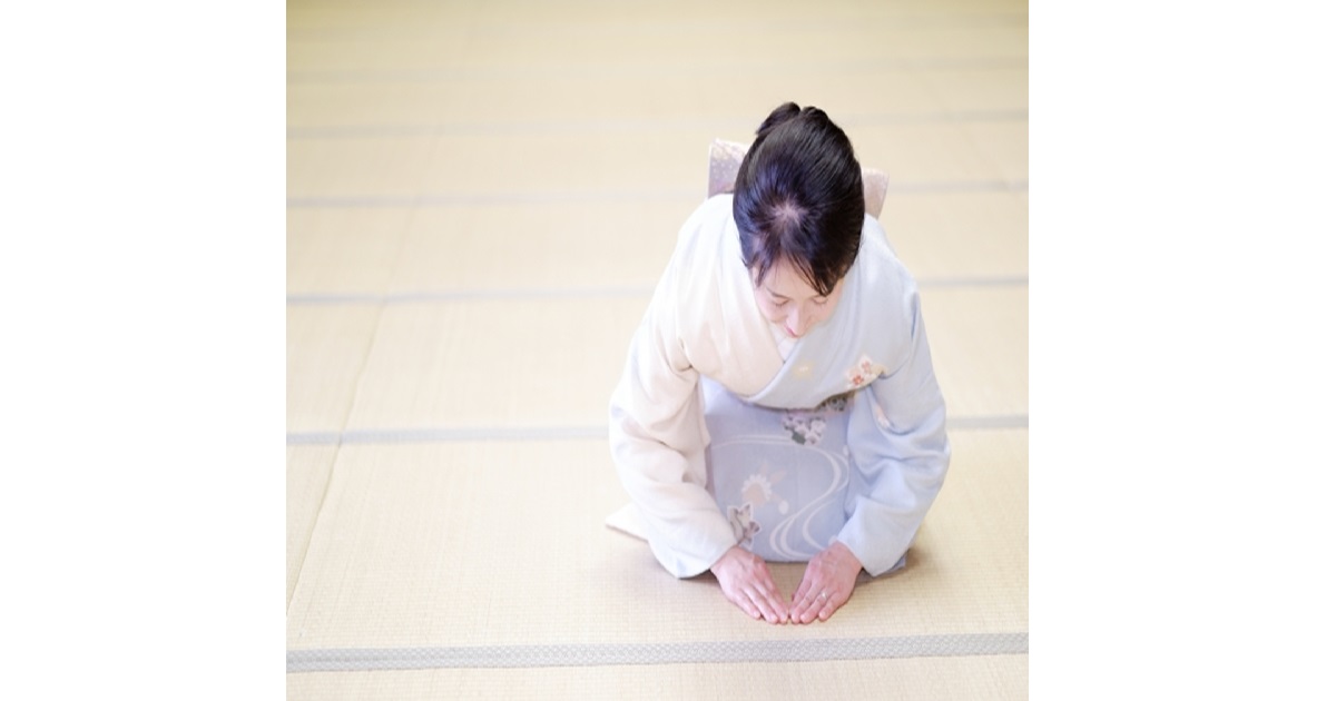 A Japanese person in traditional clothing performing a deep, respectful bow (ojigi), showcasing Japanese etiquette.
