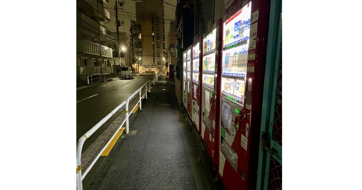 A brightly lit Japanese vending machine on a quiet street at night, symbolizing Japan's unique vending machine culture.