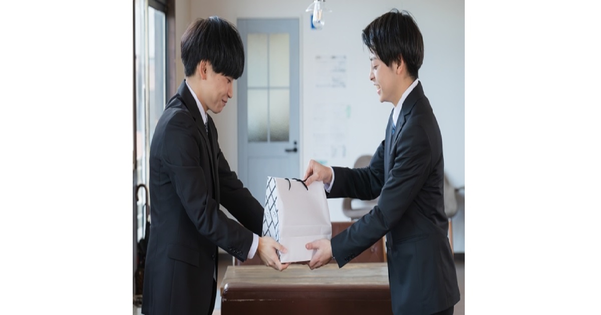 A box of famous Japanese souvenirs, or "omiyage," on an office desk, illustrating the complex social rules and unspoken debt of Japanese gift-giving culture.