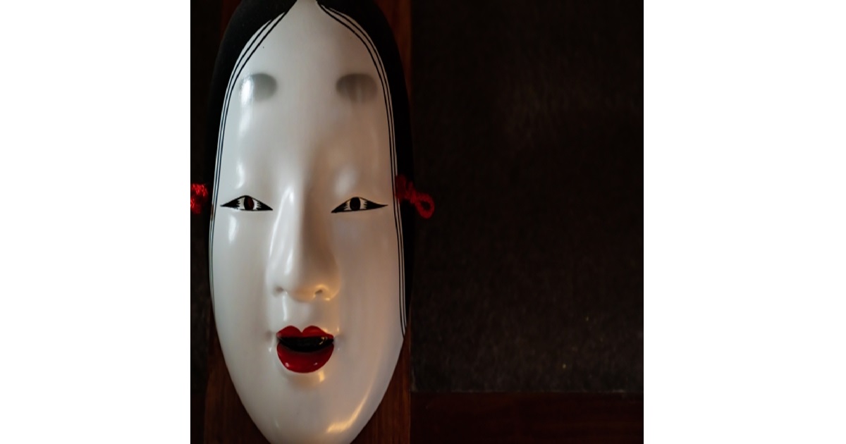 A traditional Japanese Noh mask, symbolizing the cultural concept of "Honne" (real intention) and "Tatemae" (public facade).