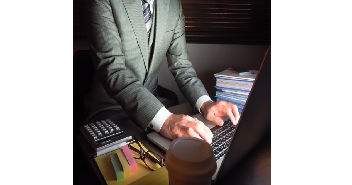 An illustration of a tired Japanese salaryman working late, representing the dark side of "Ganbaru," Japan's culture of perseverance that can lead to burnout.